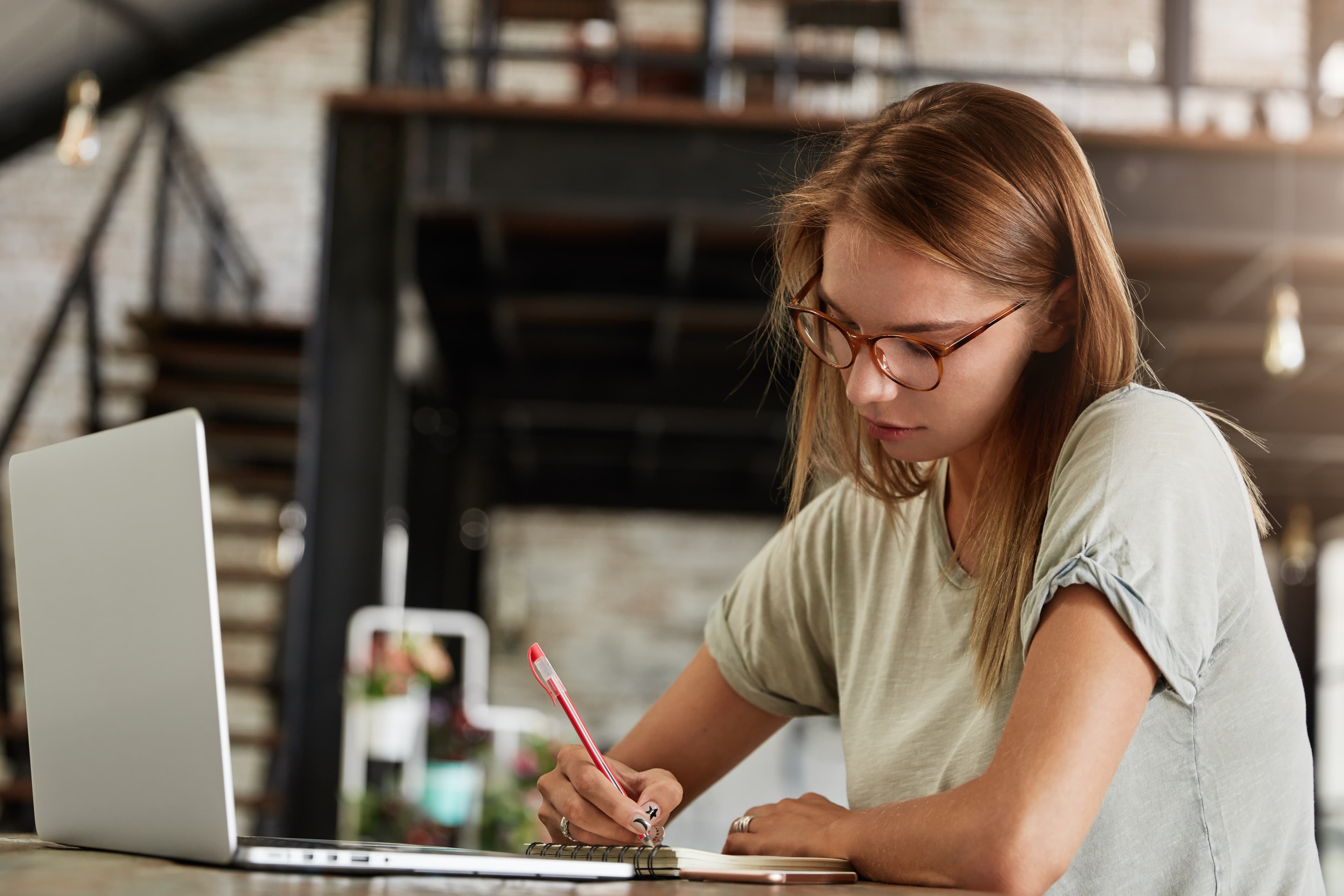 Young woman working and writing in a notebook